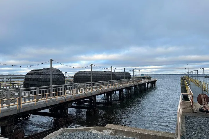 Una estructura de muelle de madera que se adentra en el mar en un día nublado.