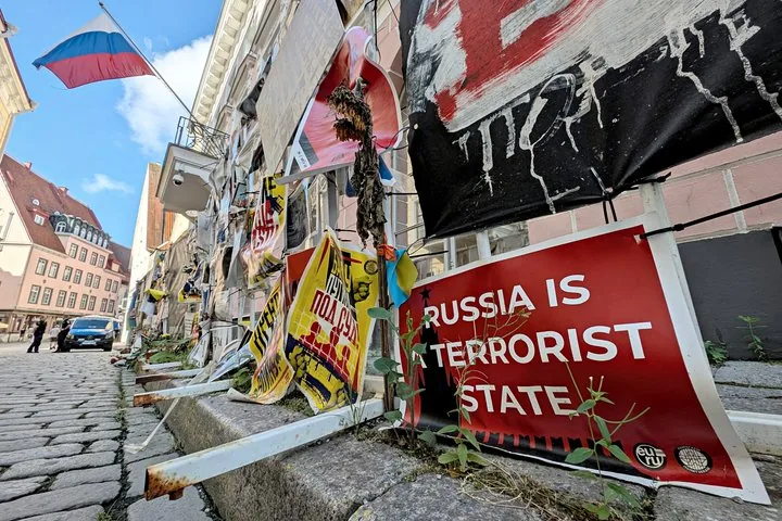 Des panneaux de protestation, y compris « La Russie est un État terroriste », le long d'une rue pavée.